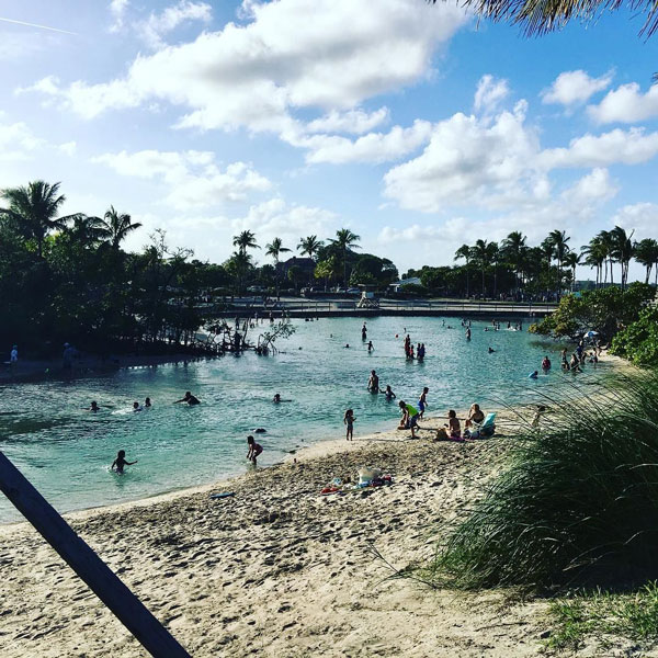 People enjoying a palm-lined Jupiter lagoon